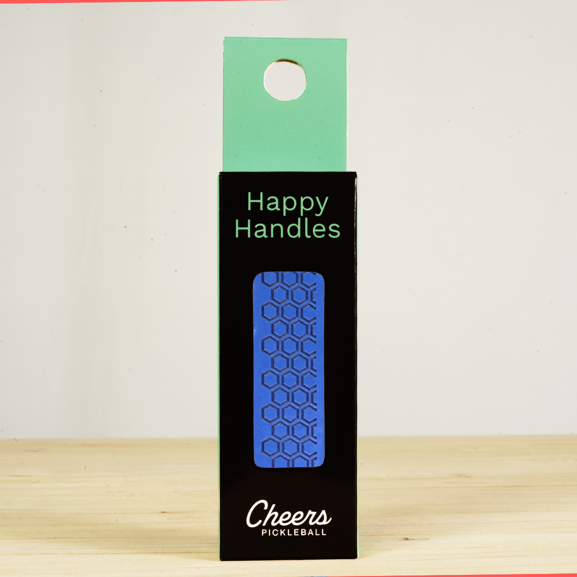 Happy Handles  Atlantic Blue Pickleball Grip in its packaging, featuring hexagon textured print, visible through the product box window
