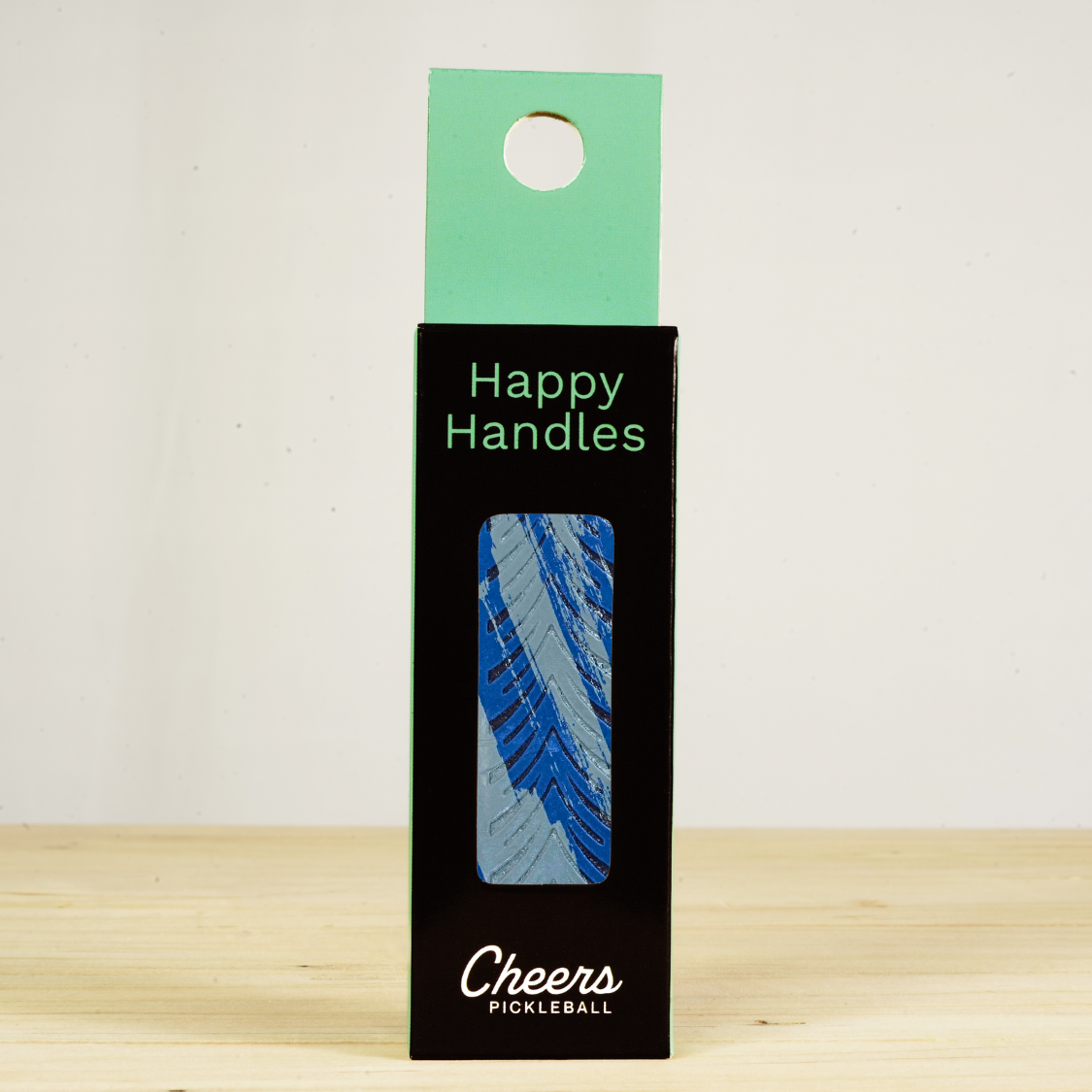 Happy Handles Brushed Blue Pickleball Grip in its packaging, featuring a brushed blue marble design, visible through the product box window