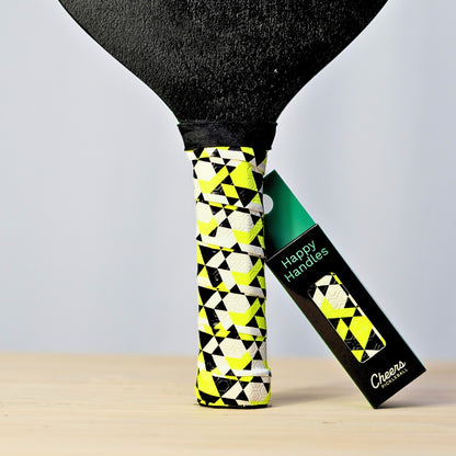 Happy Handles Electric Beehive Pickleball Grip with white, yellow, and black geometric shapes, displayed on a paddle