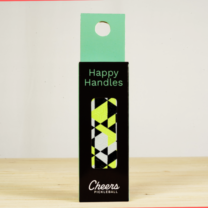 Happy Handles Electric Beehive Pickleball Grip in its packaging, featuring white, black, and yellow geometric design, visible through the product box window