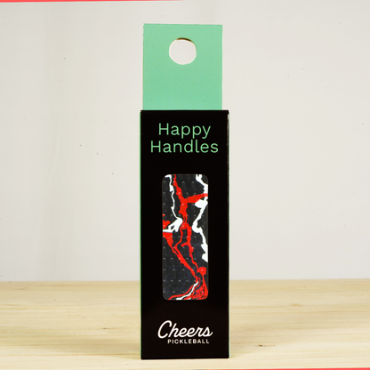 Happy Handles Paint Swirl, Black Pickleball Grip in its packaging, featuring red and white paint swirls, visible through the product box window