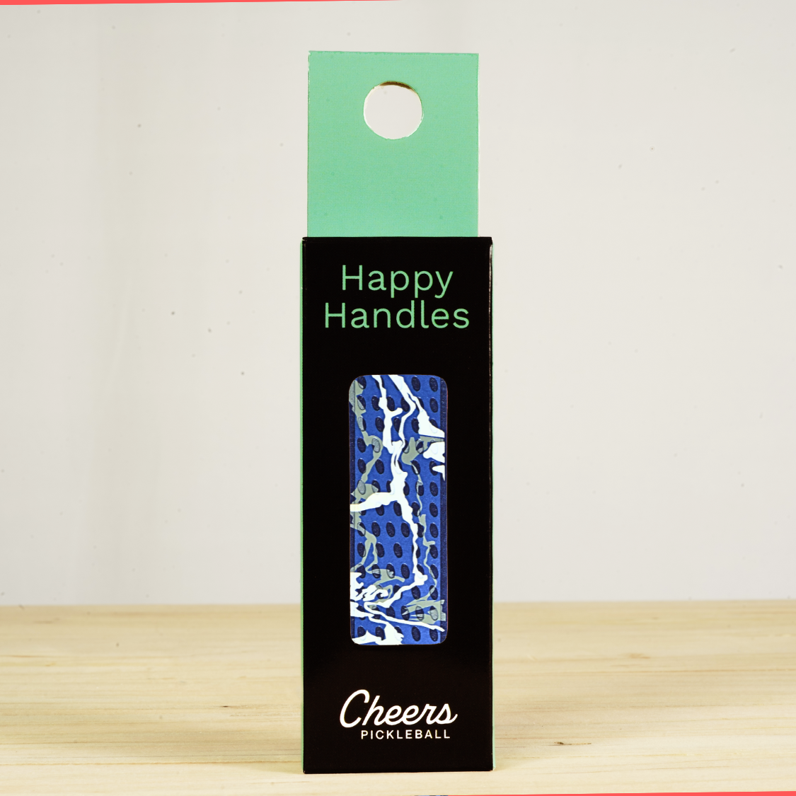 Happy Handles Paint Swirl, Blue Pickleball Grip in its packaging, featuring white and gray paint swirls, visible through the product box window