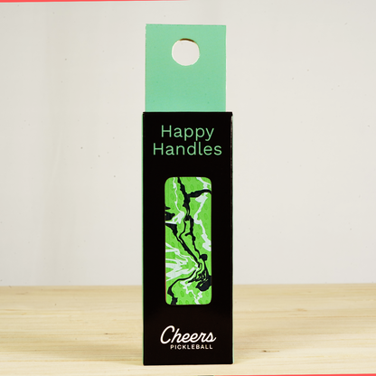 Happy Handles Paint Swirl, Green Pickleball Grip in its packaging, featuring white and black paint swirls, visible through the product box window