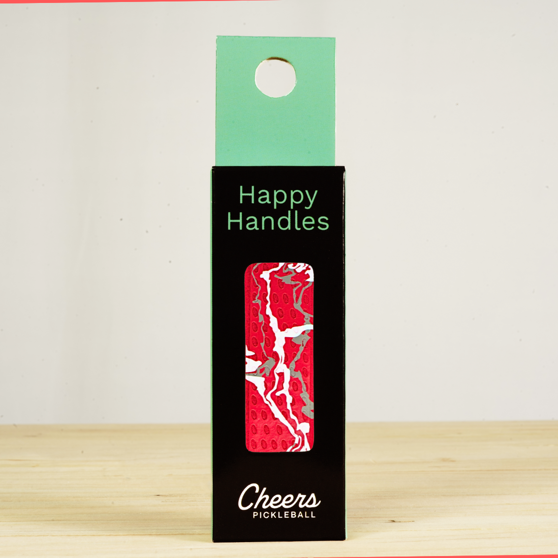 Happy Handles Paint Swirl, Red Pickleball Grip in its packaging, featuring white and gray paint swirls, visible through the product box window